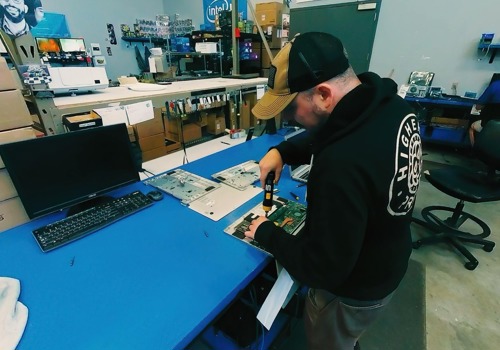 A laptop’s keyboard is worked on by a help desk technician.